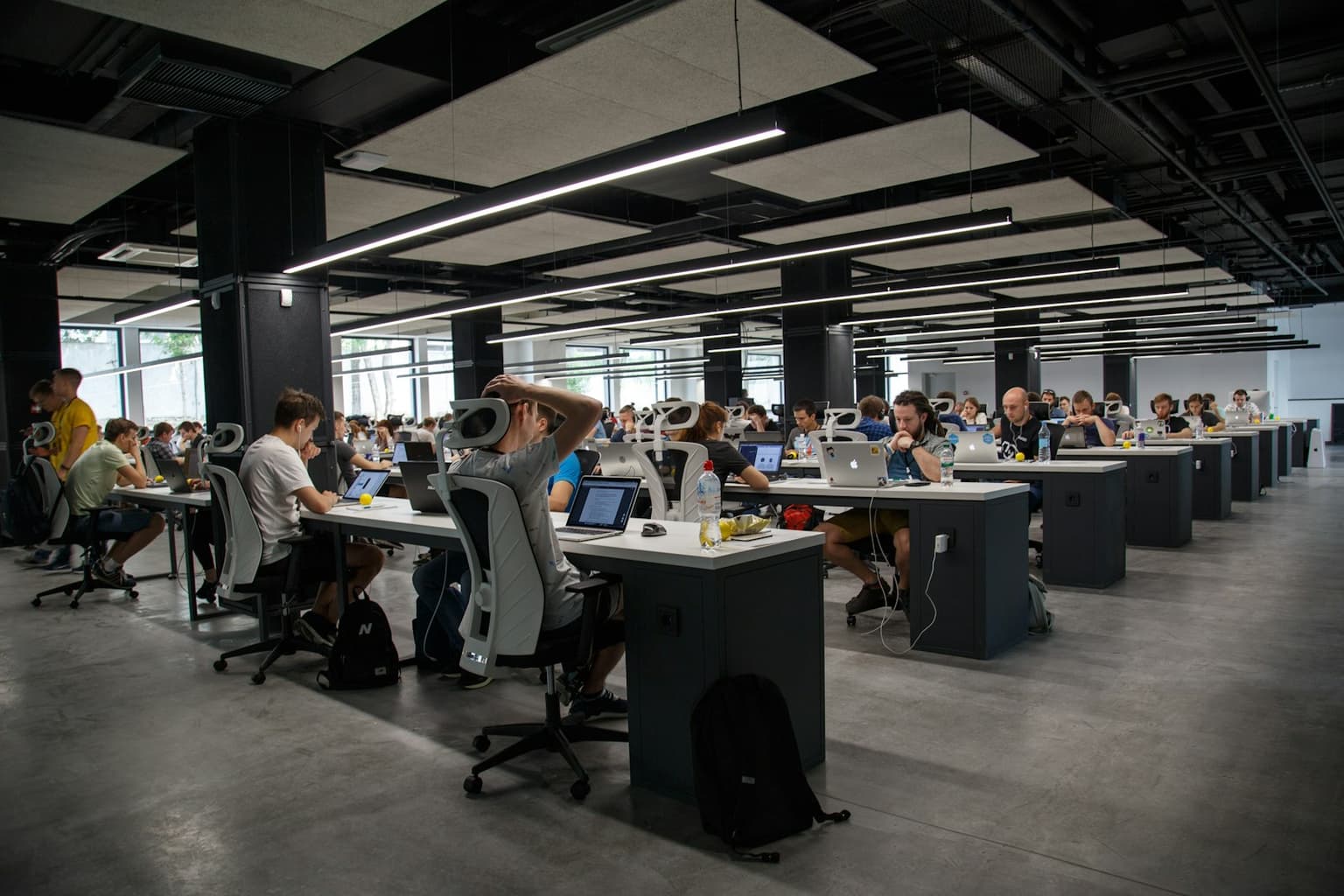 A busy open-plan office where teams run daily work on existing tools